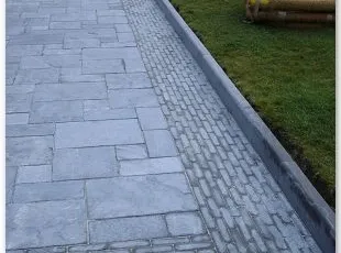 Terrasse en pierre bleue posée sur chape de sable stabilisé avec joints au sable fin + bordure en pierre bleue 100/25/8 avec bord arrondi et contour en pierre rustique 5/5/18 et l’intérieure en dalle opus romano en 4 formats.