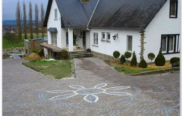 Rosace décorative avec fleur en pavés blanc marbre de carrare, joint en cours de réalisation.