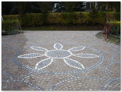 Rosace décorative avec fleur en pavés blanc marbre de carrare, joint en cours de réalisation.