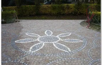 Rosace décorative avec fleur en pavés blanc marbre de carrare, joint en cours de réalisation.