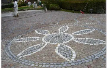 Rosace décorative avec fleur en pavés blanc marbre de carrare, joint en cours de réalisation.