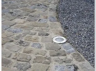 Grès de réemploi de type disparate avec les joints au mortier coulé hydrofugé + luminaire.
