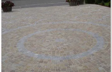 Pavés 8/10 mosaïque posés en éventail avec ligne décorative en pierre bleue avec les joints au mortier hydrofugé + boussole décorative en pierre bleue.