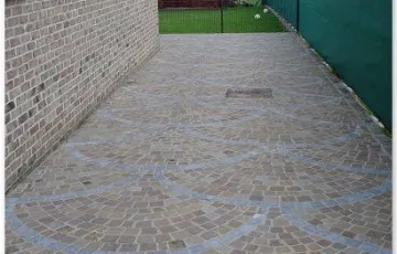 Pavés 8/10 mosaïque posés en éventail avec ligne décorative en pierre bleue avec les joints au mortier hydrofugé + boussole décorative en pierre bleue.