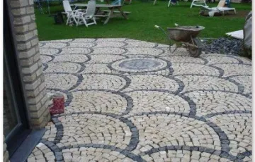 Pavés 5/7 posés en éventail avec boussole décorative en pierre bleue.
