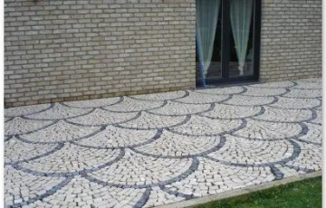 Pavés 5/7 posés en éventail avec boussole décorative en pierre bleue.