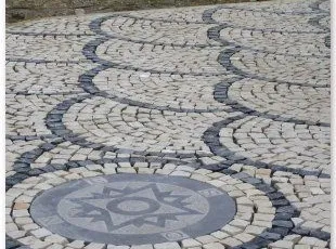 Pavés 5/7 posés en éventail avec boussole décorative en pierre bleue.