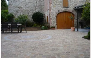 Cour intérieure en platine 14/14 kandla avec rosace décorative. Carport et terrasse en dallette en pierre bleue 20/20 avec joints au mortier coulés.
