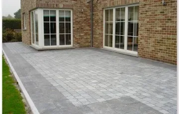 Terrasse privée réalisée en dallettes de pierre bleue Asiatique posées sur chape et joint au sable fin avec en pourtour extérieur une bordure en pierre bleue et pavé oblong.