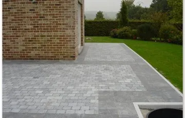 Terrasse privée réalisée en dallettes de pierre bleue Asiatique posées sur chape et joint au sable fin avec en pourtour extérieur une bordure en pierre bleue et pavé oblong.