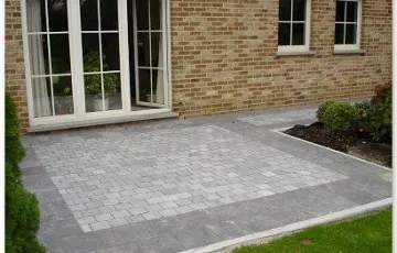 Terrasse privée réalisée en dallettes de pierre bleue Asiatique posées sur chape et joint au sable fin avec en pourtour extérieur une bordure en pierre bleue et pavé oblong.