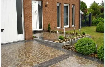 Aménagement privé, entrée de garage en pierre bleue 25/10/5, mosaïque 8/10 grès indien avec joint au Groutex. Palissade granit + déco jardin galet de rivière . Luminaire sur pied.