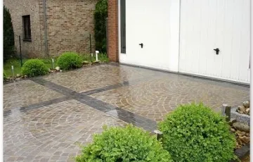 Aménagement privé, entrée de garage en pierre bleue 25/10/5, mosaïque 8/10 grès indien avec joint au Groutex. Palissade granit + déco jardin galet de rivière . Luminaire sur pied.