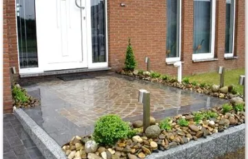 Aménagement privé, entrée de garage en pierre bleue 25/10/5, mosaïque 8/10 grès indien avec joint au Groutex. Palissade granit + déco jardin galet de rivière . Luminaire sur pied.