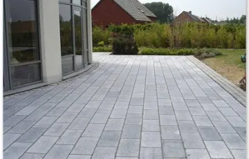 Terrasse privée avec des dalles de pierre bleue 30/60 de type rustique polie. Pourtour avec des 14/14 platine Asiatique.