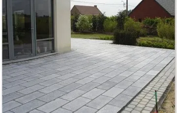 Terrasse privée avec des dalles de pierre bleue 30/60 de type rustique polie. Pourtour avec des 14/14 platine Asiatique.