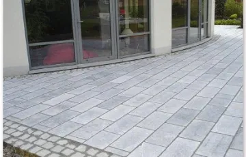 Terrasse privée avec des dalles de pierre bleue 30/60 de type rustique polie. Pourtour avec des 14/14 platine Asiatique.