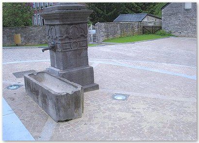 Aménagement public : église d’Aywaille Pourtour fontaine réalisé en pavés mosaïques 8/10 grès neufs d’importation, bordure petit granit neuf joint au coulis de mortier