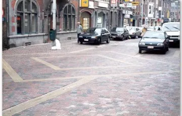 Visé – rue Haute pavés béton 15/15 tambourisés ralentisseur décoratif en pavés 7/9 mosaïques et 7/9 « blanc de Carrare » joints à l’émulsion incolore